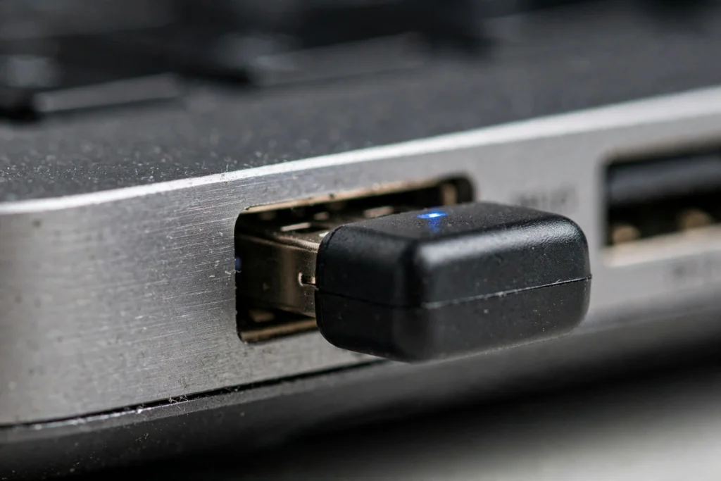 USB Bluetooth dongle being plugged into a laptop